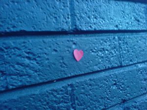 Muro blu con attaccato un cuore viola