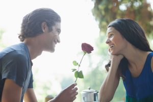 Un ragazzo regala una rosa a una ragazza