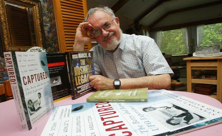 Stanton Friedman - am Tisch sitzend mit Büchern