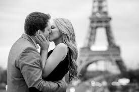 Due giovani si baciano calorosamente con la Tour Eiffel sullo sfondo