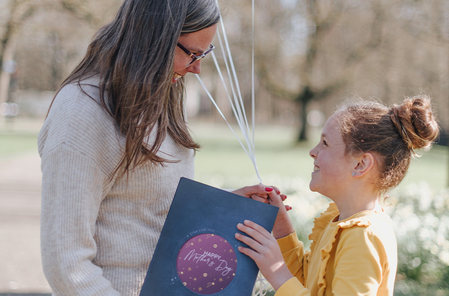 Menina entregando um pacote de presentes OSR para sua mãe